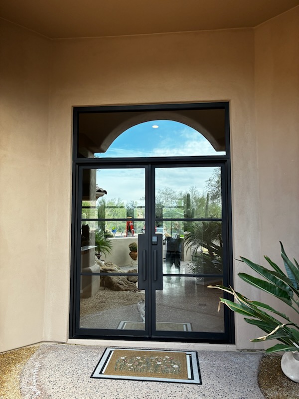 Single arched iron and glass entry door