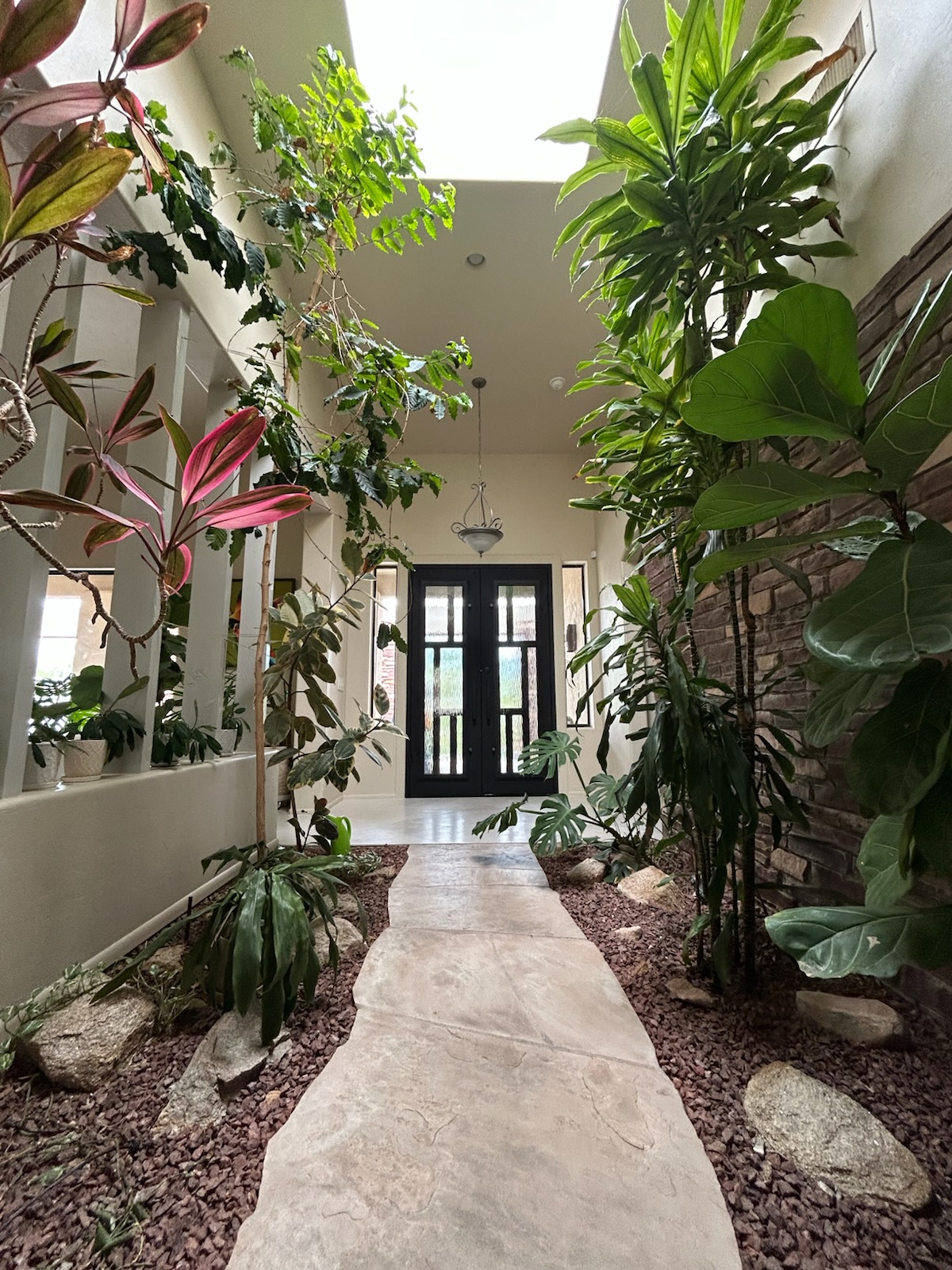 Garden walkway leading to an iron entry door